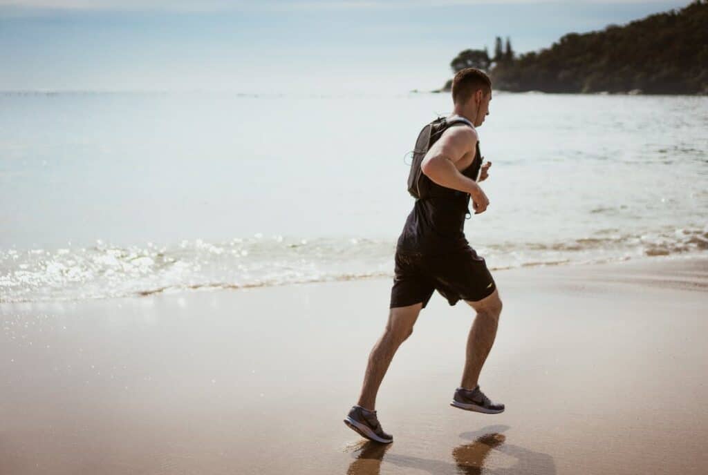 Back of a Man Mid-Run on a Beach