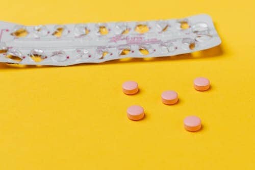 Strips of Pills Lying Haphazardly on a yellow surfaceViagra