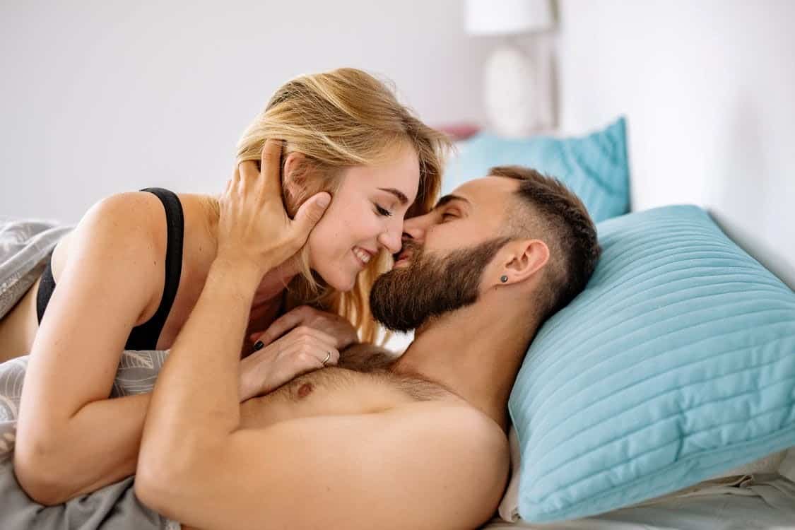 A Half-Naked Woman Getting Intimate with a Shirtless Man in Bed